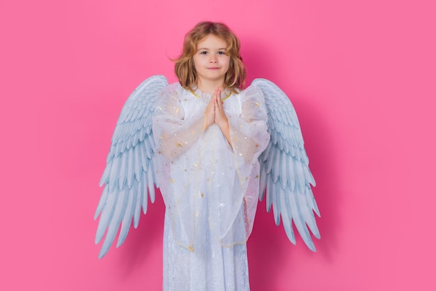 Engelsgebet kleiner Amor-Kind-Engel mit Engelsflügeln isoliert auf rosa Studiohintergrund Valen