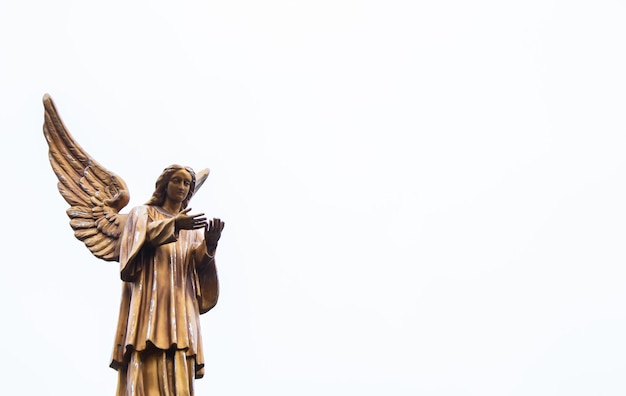 Engelsstatue auf weißem Hintergrund Traurige Engelsfigur am bewölkten Himmel