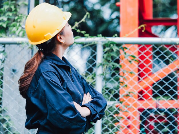 Foto engenharia inteligente mulher bonita em pé sério na frente de um guindaste