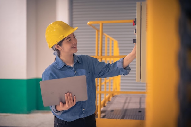 Engenheira asiática usando computador trabalhando na fábrica