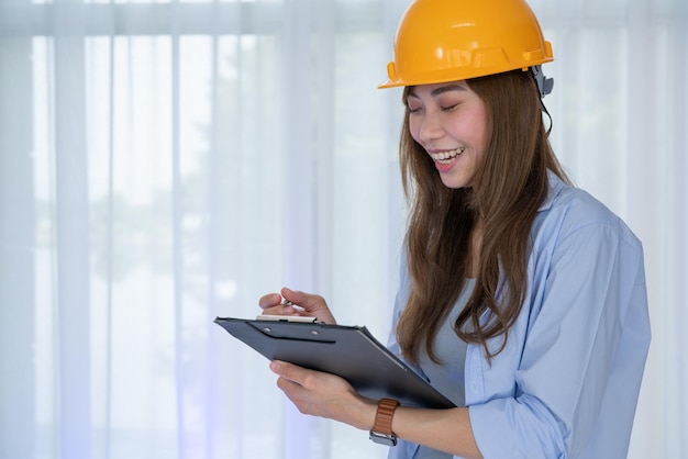 Engenheira-chefe, mulher com capacete amarelo, verifique a exatidão da construção