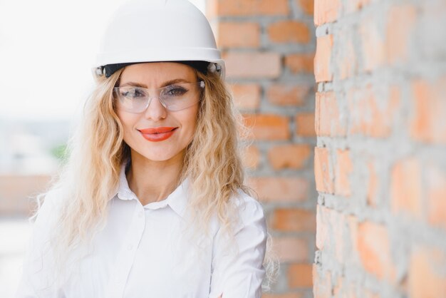 Foto engenheira de construção. arquiteto com um computador tablet em uma construção. jovem mulher olhando, construindo local de construção no fundo. conceito de construção