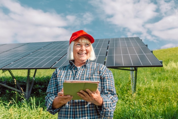 Engenheira de empresária usando tablet perto de painéis solares tecnologia de energia renovável