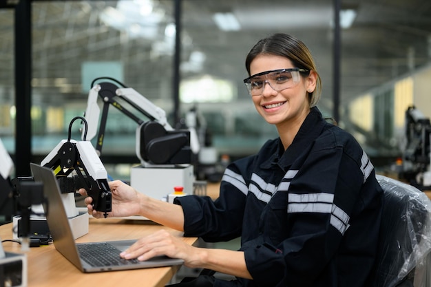 Foto engenheira técnica feminina usando laptop verificando máquina robótica