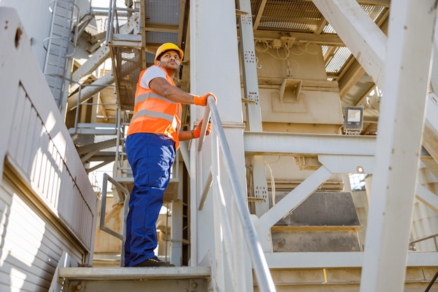 Engenheiro africano sério em pé no local industrial