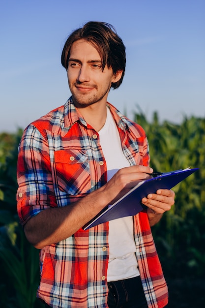 Engenheiro agrônomo homem feliz em um campo de milho, tendo o controle do rendimento - Inage