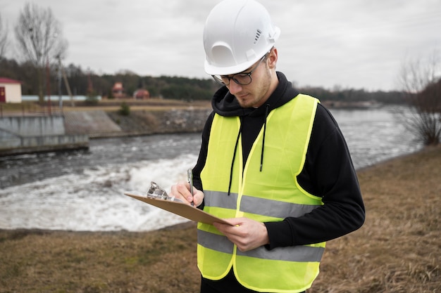 Engenheiro ambiental de tiro médio tomando notas