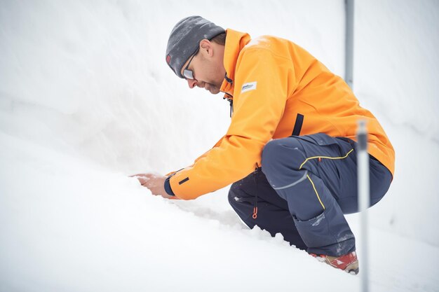 Engenheiro analisando a estabilidade da camada de neve em uma encosta íngreme