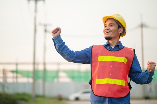 Engenheiro asiático em pé ao ar livre na construção do local postando confiante Engenheiro de construção feliz sucesso no trabalho com planejamento alvo