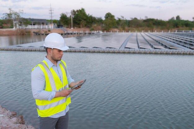 Engenheiro asiático trabalhando na fazenda solar flutuanteEnergia renovávelTécnico e investidor painéis solares verificando os painéis na instalação de energia solar