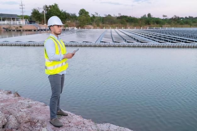 Engenheiro asiático trabalhando na fazenda solar flutuanteEnergia renovávelTécnico e investidor painéis solares verificando os painéis na instalação de energia solar