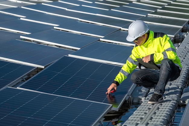 Engenheiro asiático trabalhando na usina de energia solar flutuante, energia renovável