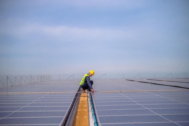 Engenheiro asiático verificando energia de célula de energia solar no telhado da fábrica Trabalhador asiático trabalhando para instalar sistema de célula solar de energia solar para usar energia solar limpa