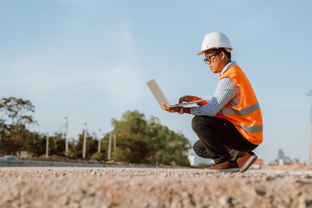 Engenheiro civil no canteiro de obras usando o computador laptop, verificando o trabalho. gestão no canteiro de obras.