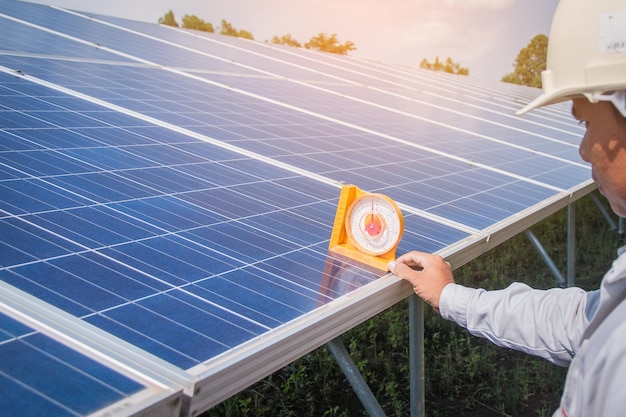 Engenheiro cortado segurando equipamento de medição em painel solar