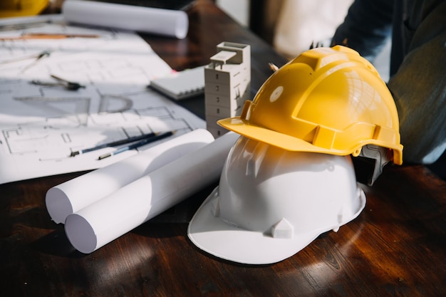 Engenheiro de canteiro de obras de dois homens de negócios Objetos de engenharia no local de trabalho com parceiros interagindo em segundo plano