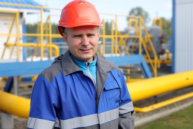 Engenheiro de capacete e macacão nas instalações de produção um retrato real de um trabalhador da indústria de gás