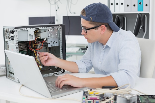 Engenheiro de computação trabalhando no console quebrado com laptop