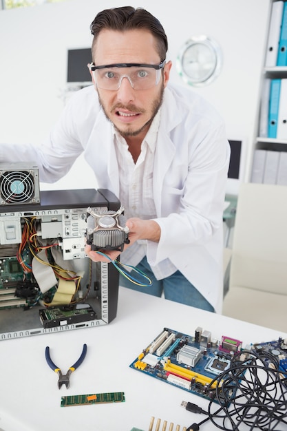 Engenheiro de computador estressado mostrando ventilador quebrado