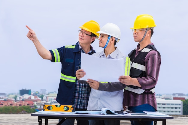 Engenheiro de construção asiáticos e seus capatazes trabalhando juntos no canteiro de obras