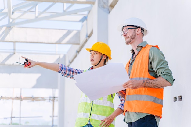 Engenheiro de construção com equipe de arquiteto trabalhando verificando o progresso da construção no canteiro de obras