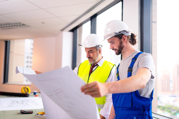 Engenheiro de construção com trabalhador capataz verificar canteiro de obras