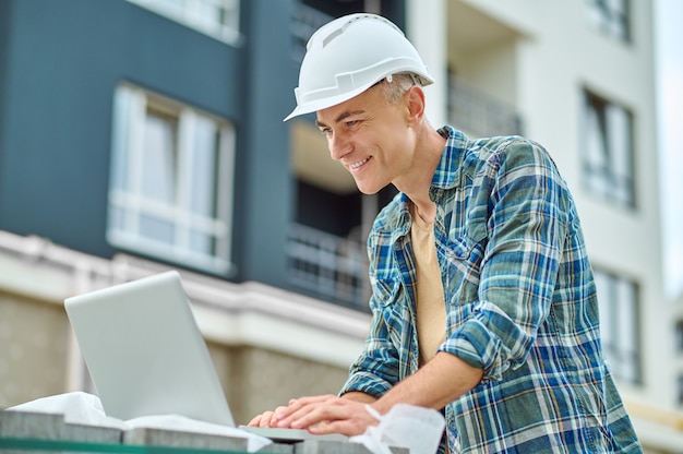 Engenheiro de construção focado usando seu gadget no canteiro de obras