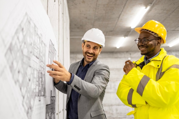 Engenheiro de construção ou arquiteto apresentando plano de construção e projeto para o trabalhador no local