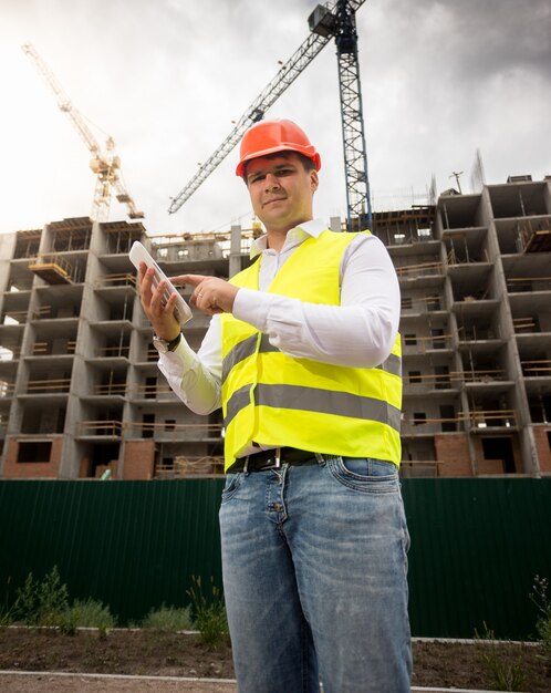 Engenheiro de construção sorridente posando com tablet digital