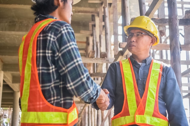 Engenheiro de equipe arquiteto de dois homens em um canteiro de obras