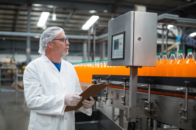 Foto engenheiro de fábrica, mantendo o registro na área de transferência na fábrica