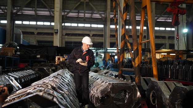 Engenheiro de fábrica ou trabalhador de capataz mantendo peças de equipamentos de verificação na fábrica