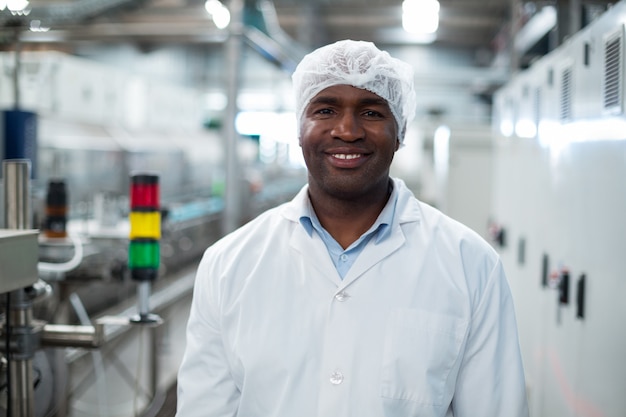 Engenheiro de fábrica sorridente em pé na fábrica de garrafas