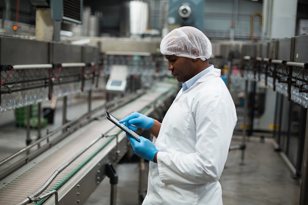 Engenheiro de fábrica usando tablet digital na fábrica