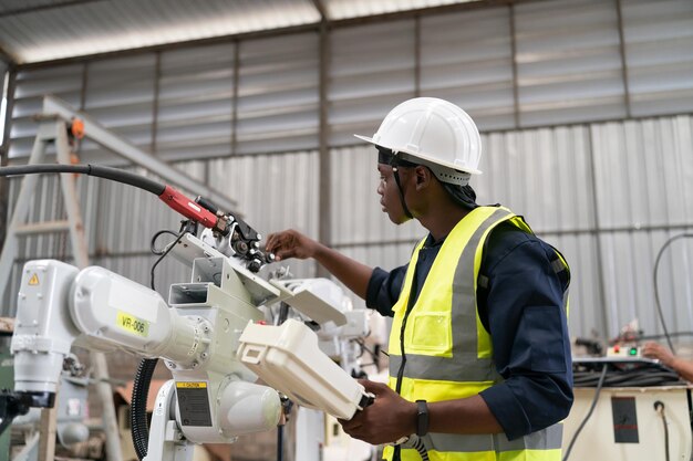 Engenheiro de robótica trabalhando na manutenção do braço robótico moderno no armazém da fábrica Business technoloy