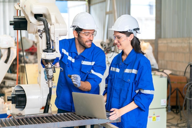 Engenheiro de robótica trabalhando na manutenção do braço robótico moderno no armazém da fábrica