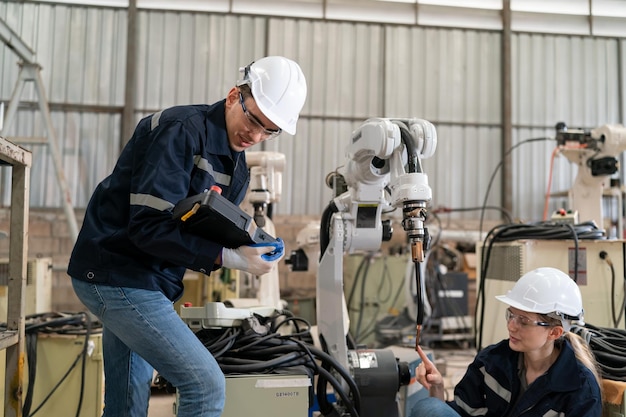 Engenheiro de robótica trabalhando na manutenção do braço robótico moderno no armazém da fábrica