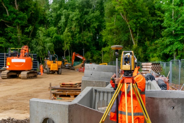 Engenheiro de site Surveyor com estação de posicionamento total no canteiro de obras