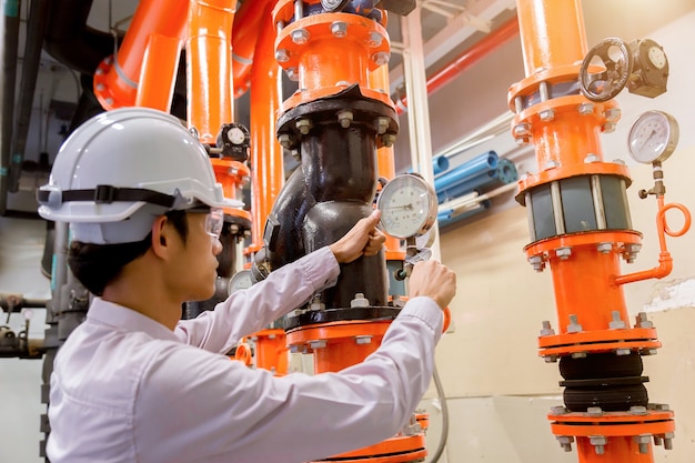 Engenheiro de verificação da bomba de água do condensador e manômetro.