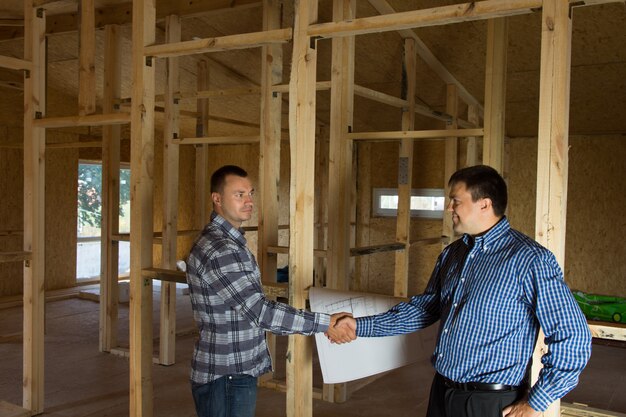 Engenheiro e arquiteto, mostrando o aperto de mão no canteiro de obras, enfatizando que ambos concordaram com a concepção do projeto.