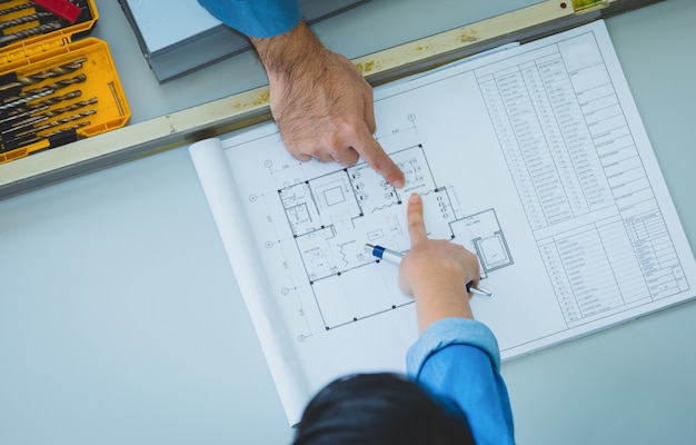 Engenheiro, e, arquitetos, discutir, e, apontar, para, disposição, predios, em, desenhos técnicos, ligado, tabela, em, fábrica