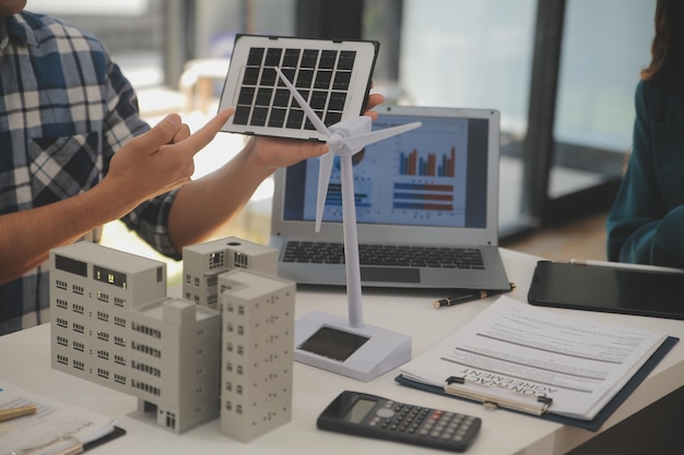 Engenheiro elétrico com um empresário discutindo o novo projeto de instalação de painéis de células solares no telhado do edifício Conceito de energia alternativa