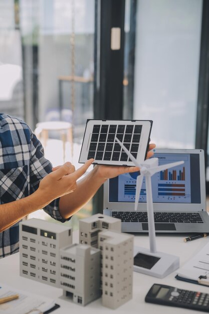 Engenheiro elétrico com um empresário discutindo o novo projeto de instalação de painéis de células solares no telhado do edifício Conceito de energia alternativa