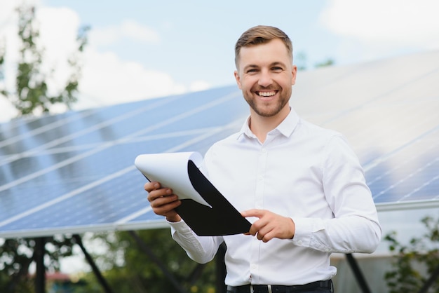 Foto engenheiro em usina de energia solar com painel solar aulas práticas sobre usinas de energia renovável