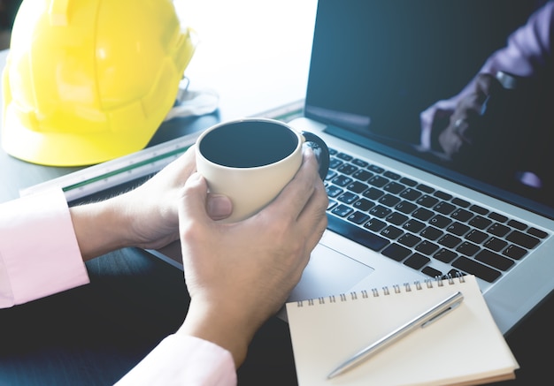 Engenheiro está tomando café trabalhando de manhã no escritório