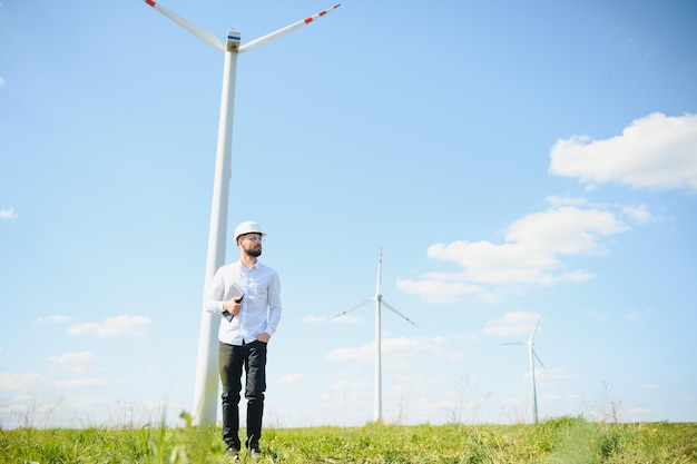 Engenheiro está verificando a produção de energia em turbinas eólicas Trabalhador no parque de moinhos de vento