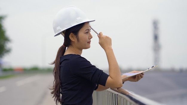 Engenheiro feminino asiático, verificando o trabalho.