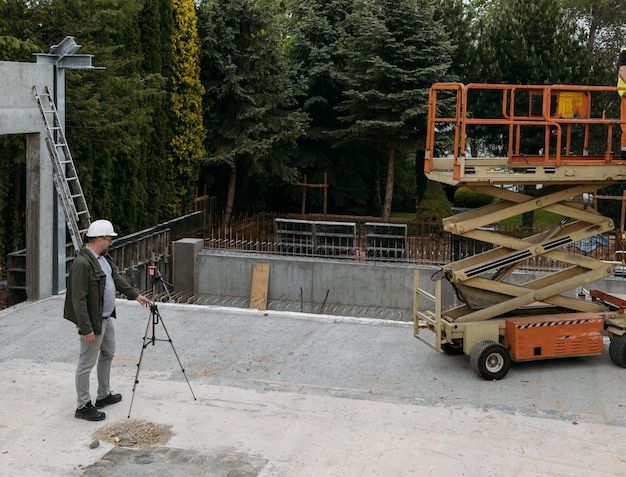 Foto engenheiro geodésico de obras geodésicas que utiliza equipamentos geodésicos no local de construção profissional