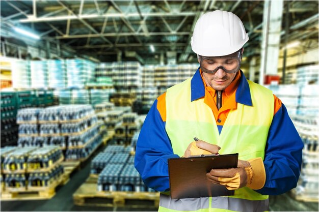 Foto engenheiro industrial a escrever num bloco de notas numa fábrica