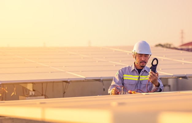 Engenheiro inspeciona painéis solares no telhado de uma casa moderna. conceito ecológico de energia alternativa.